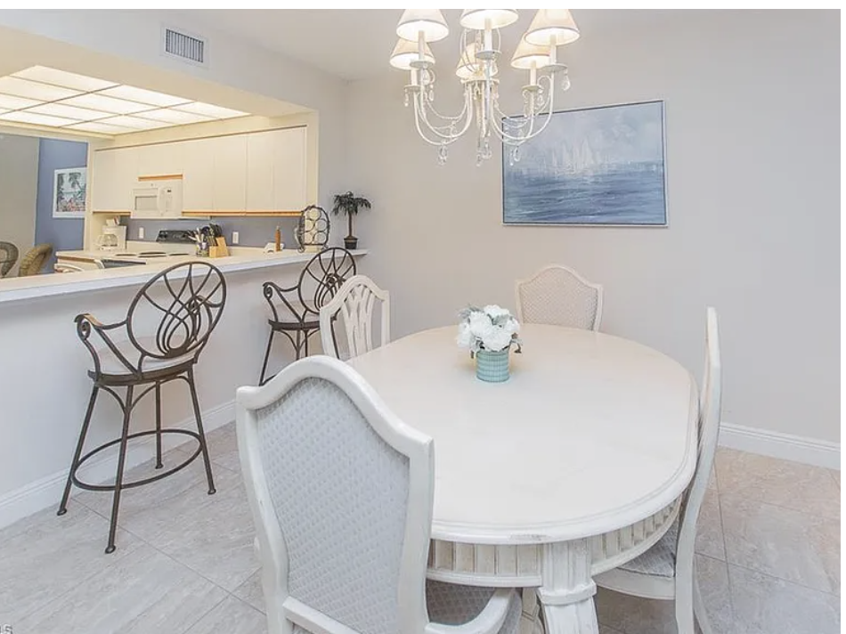 Gather around the elegant dining table under a sparkling chandelier, perfect for morning coffee or evening meals with friends and family. The open layout flows seamlessly into the kitchen, creating a welcoming space for conversation and connection.