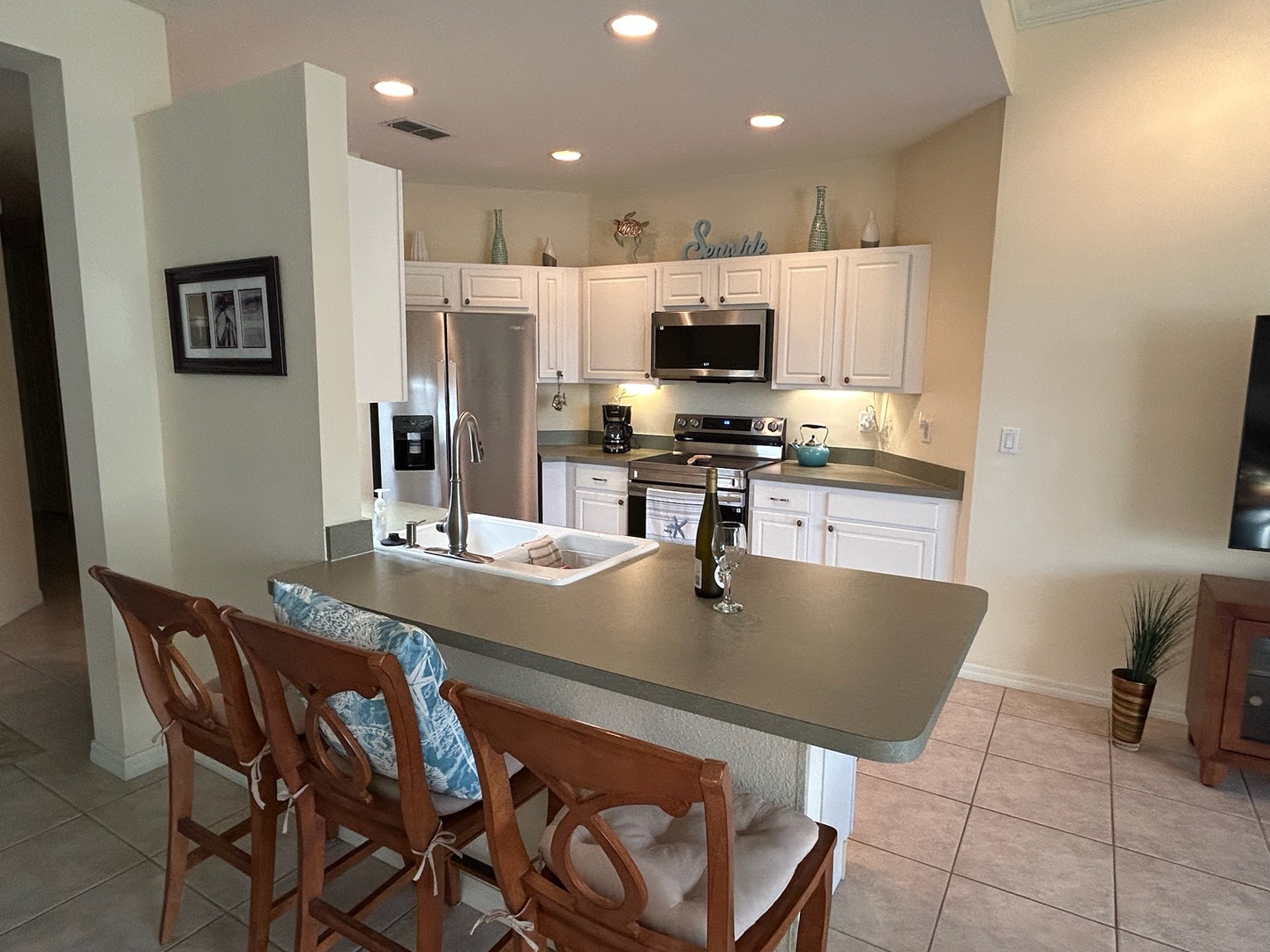 Your fully equipped kitchen awaits with stainless appliances, breakfast bar seating, and everything you need to whip up vacation meals together.