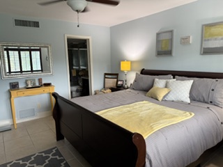 Step into your peaceful master suite, where a plush king bed, soft linens, and a cheerful yellow accent invite you to unwind. The kitchenette adds extra convenience during your stay.