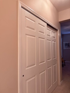 Clean built-in closets with sliding panel doors offer generous storage space for your belongings in this well-organized bedroom area.