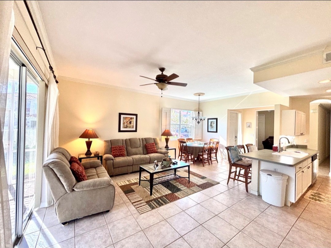 Relax in your spacious open-concept living area with plush seating, modern kitchen island, and warm natural light streaming through large windows.