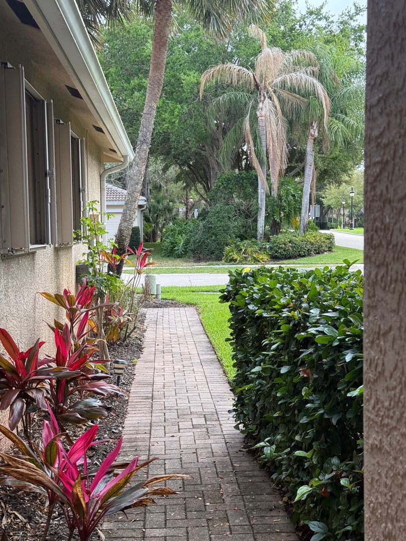 Tropical landscaping with palm trees and lush gardens surround the property, creating a peaceful outdoor environment.