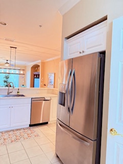 Step into a bright, open kitchen where stainless steel appliances and white cabinetry create a fresh, modern space. You'll love the natural light and clean lines, perfect for preparing meals and gathering with loved ones.