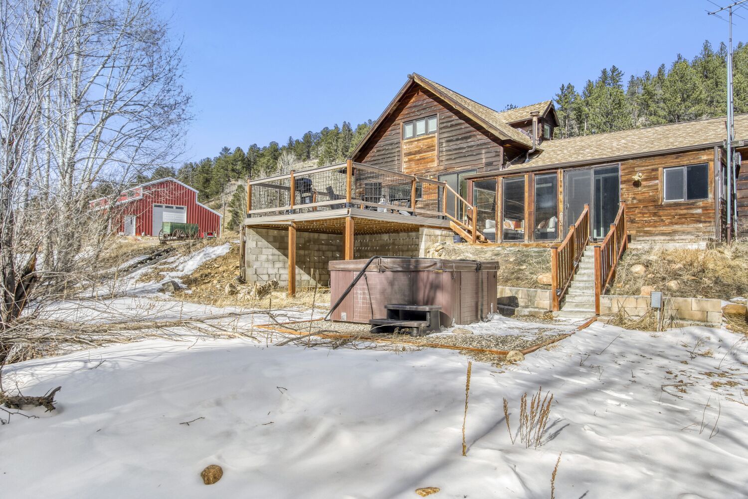 Rustic mountain retreat with modern wood construction, featuring multi-level decking and scenic alpine surroundings.