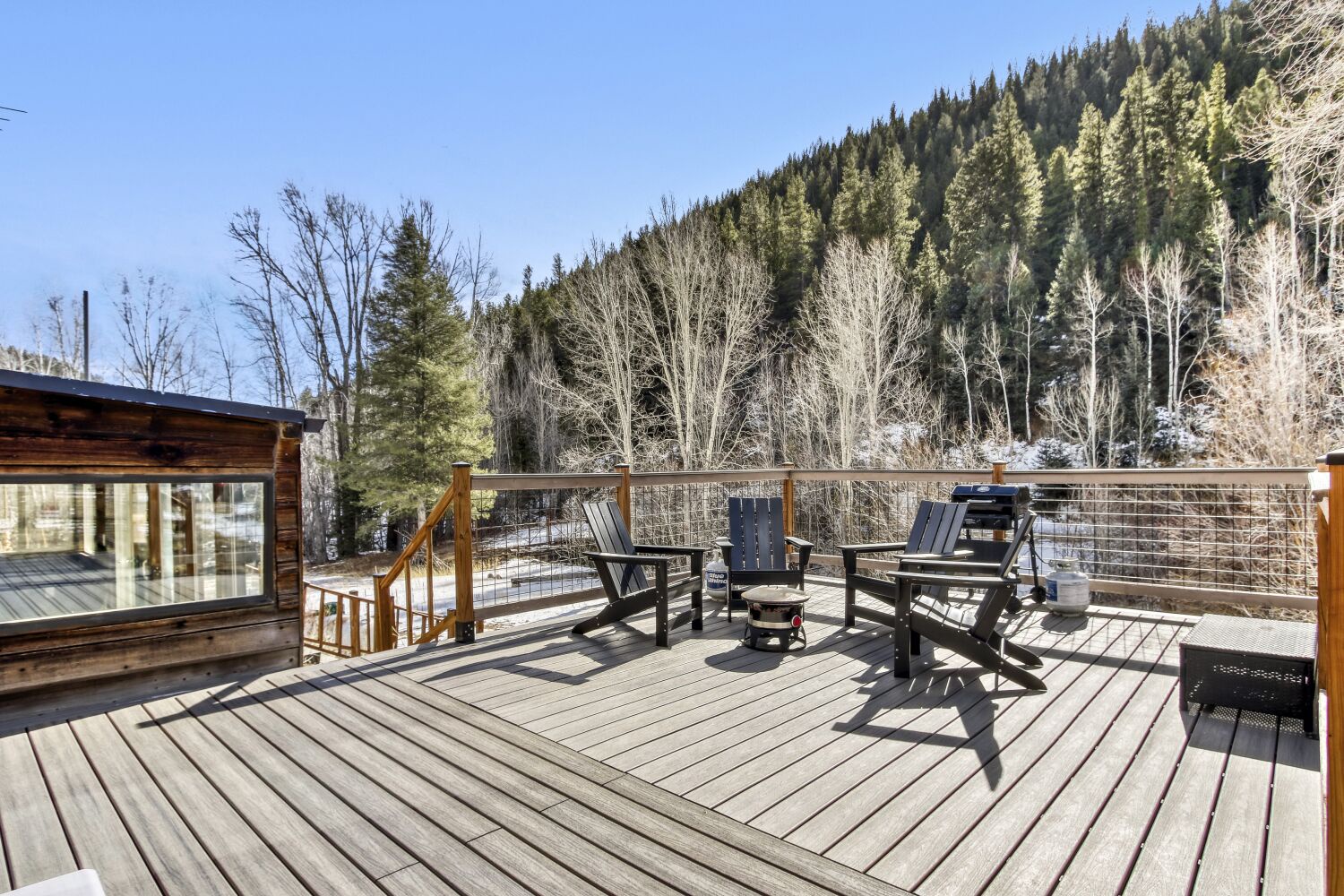 Your private deck offers mountain views, a creek running through the back of the property, and comfortable seating for morning coffee or evening relaxation surrounded by winter's quiet beauty.