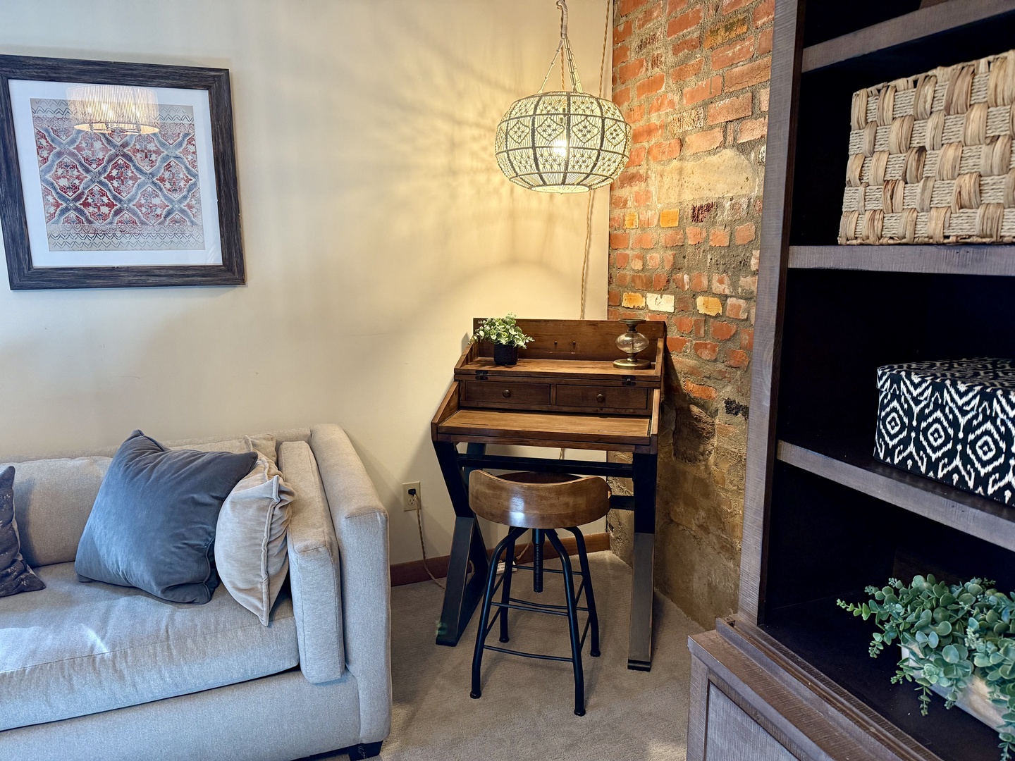 Relax in your stylish living space with exposed brick charm, and a cozy work nook perfect for quiet moments.