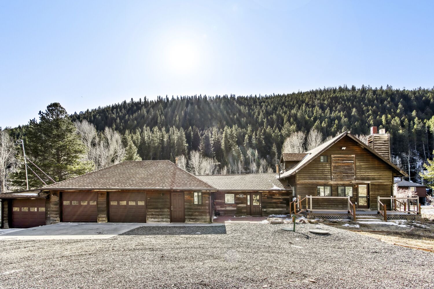 Mountain chalet nestled among snow-dusted forests with expansive parking and rustic wooden architecture.