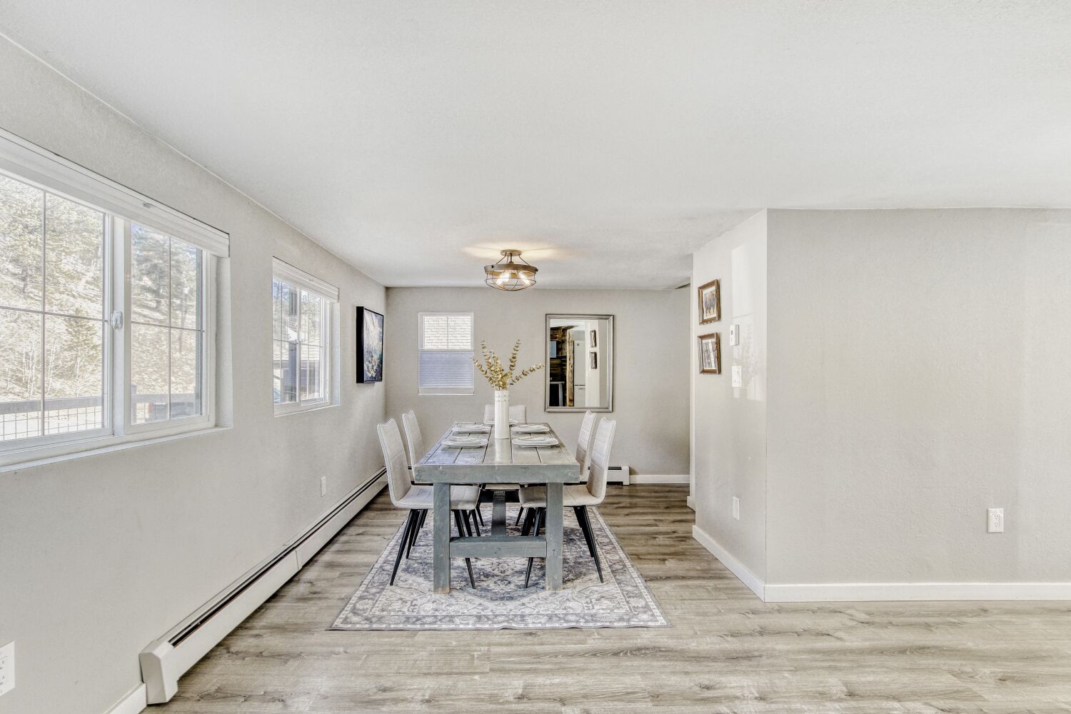 Gather around this elegant dining table where natural light streams through large windows, creating the perfect setting for memorable meals together.
