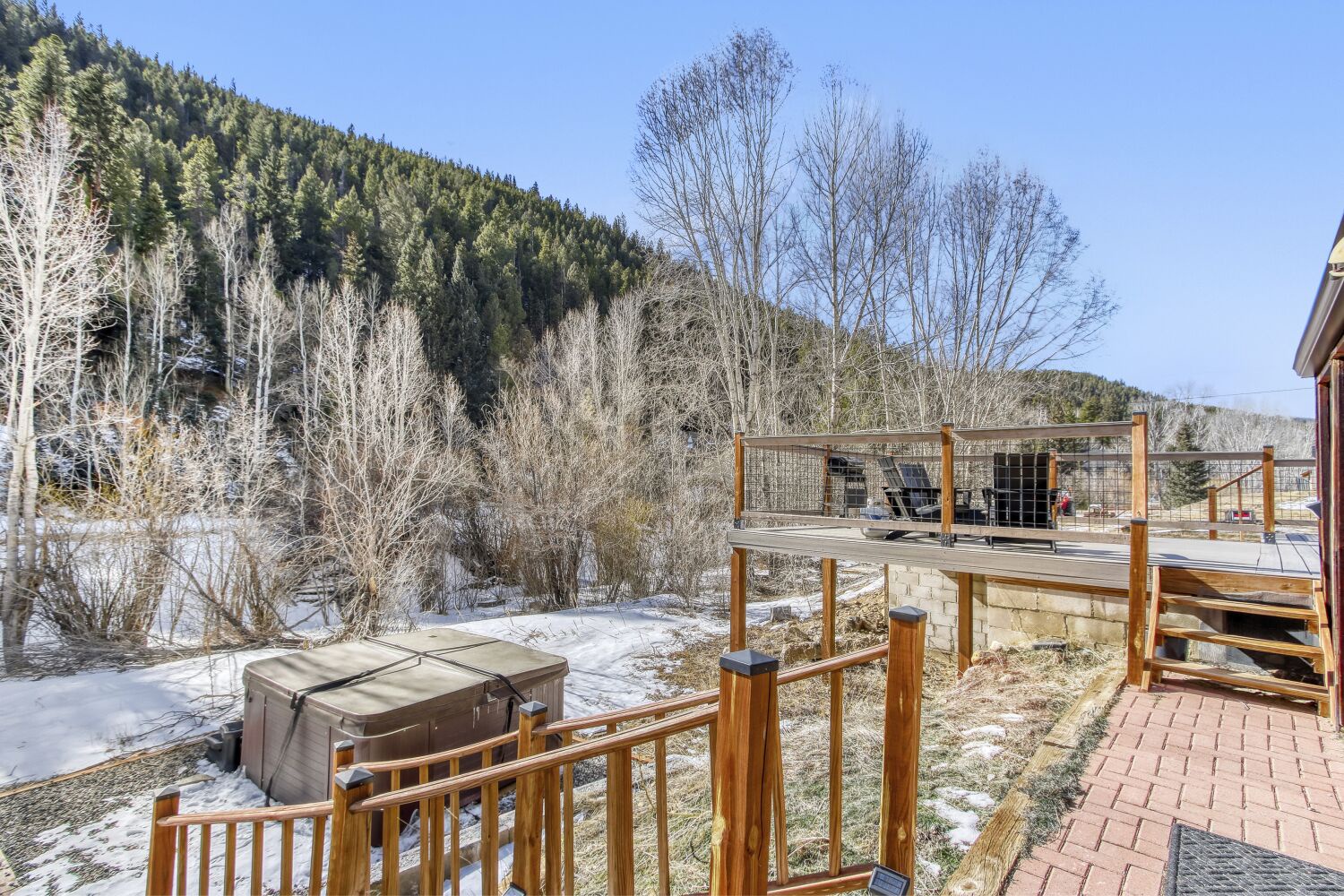 Stunning mountain views greet you from this elevated deck, where winter's beauty frames the forested landscape beyond.