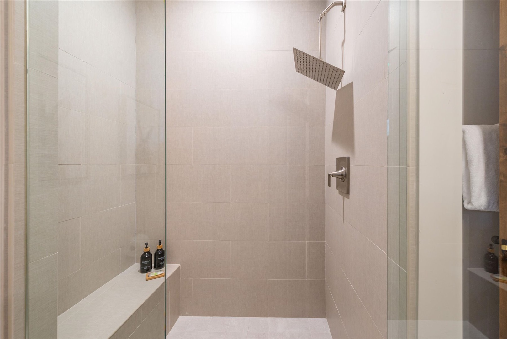 Step into your luxurious walk-in shower with modern rain head and premium amenities for ultimate relaxation.
