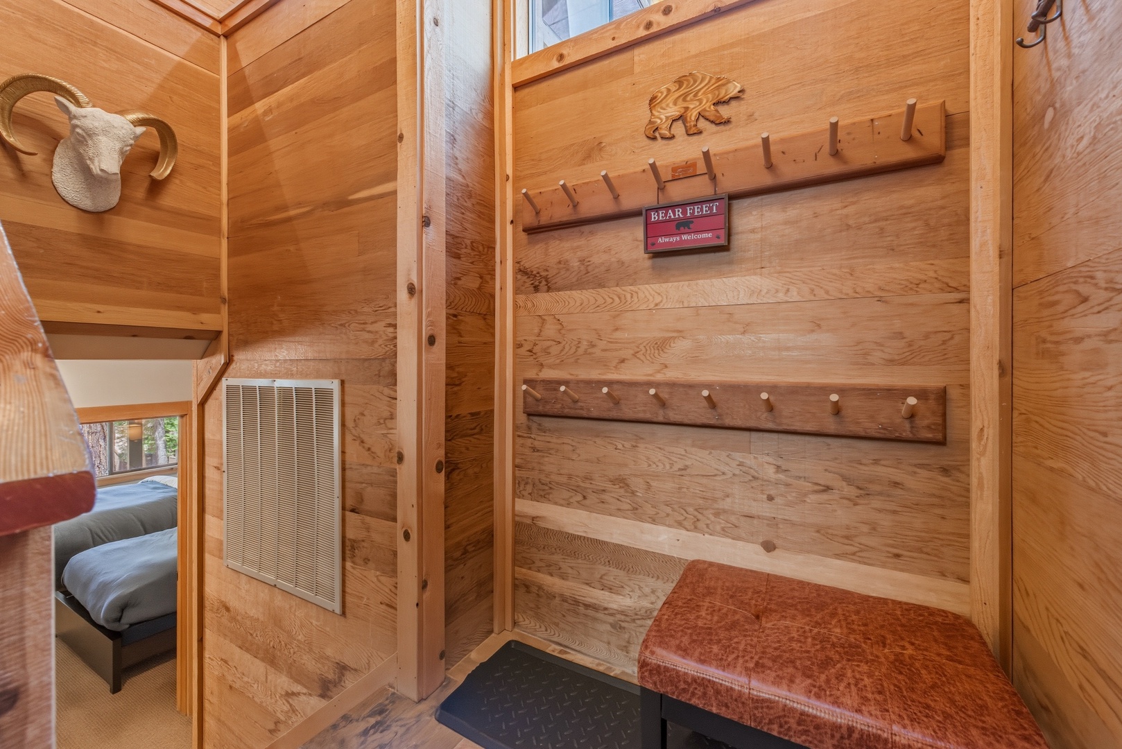 Welcome to your cozy cabin retreat. Hang your gear on rustic wood hooks and settle onto the plush bench—your mountain escape begins here.