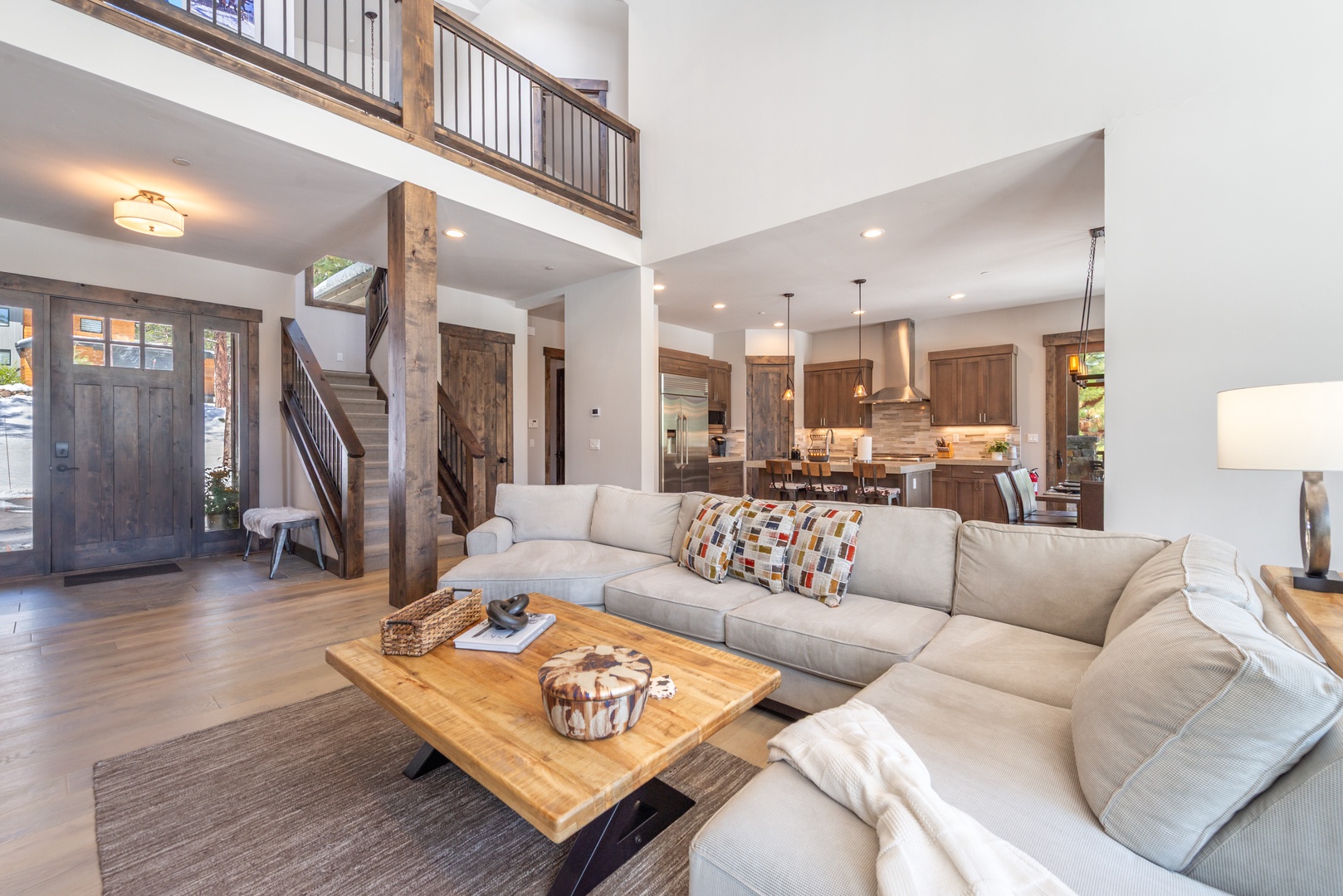 Sink into plush sectional seating where rustic wood beams meet modern comfort in your spacious open-concept living area.