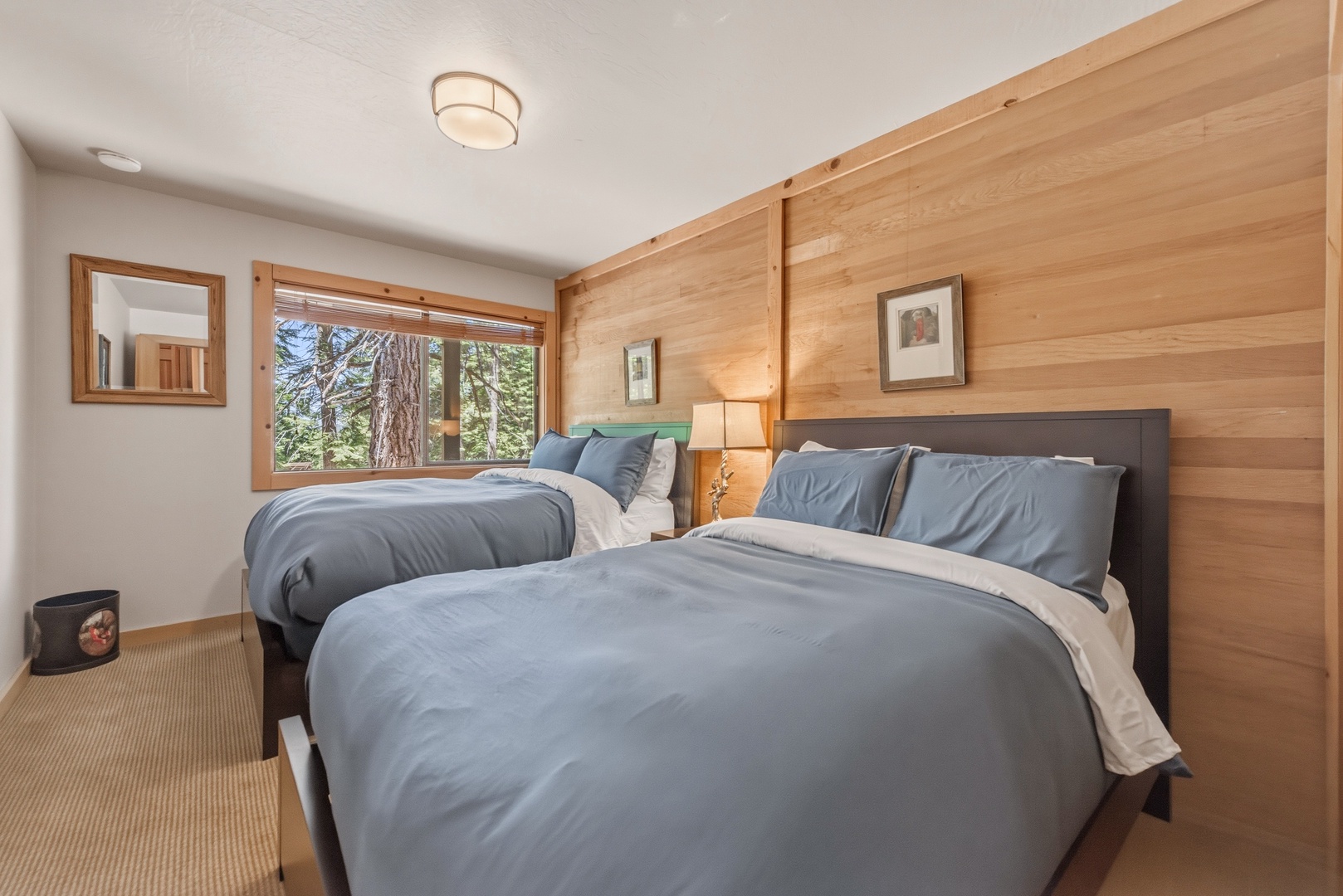 Drift off in your peaceful retreat with plush bedding and warm wood tones. Wake to serene forest views through your private window—a restful escape awaits.