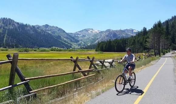Mountain biking path winds through the valley with stunning alpine views and meadows nearby. Ideal for exploring the surrounding natural landscape.