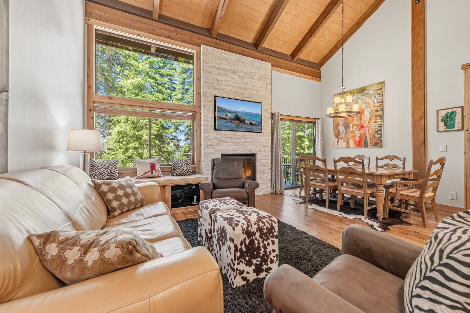 Vaulted ceilings and floor-to-ceiling windows fill your living space with natural light, while the stone fireplace and open layout create a perfect gathering spot for relaxation and connection.