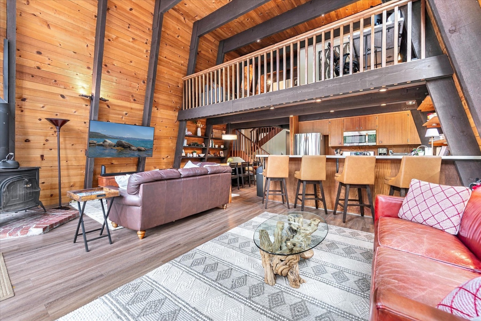 Soaring wood-beamed ceilings and an open loft create a spacious, inviting mountain retreat where you'll gather around the cozy fireplace or share meals at the kitchen bar.