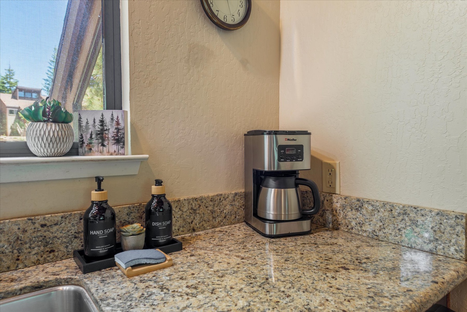 Wake up to fresh coffee brewed on your granite countertop, with natural light streaming through your window and thoughtful touches like dish soap and hand soap ready for your convenience.