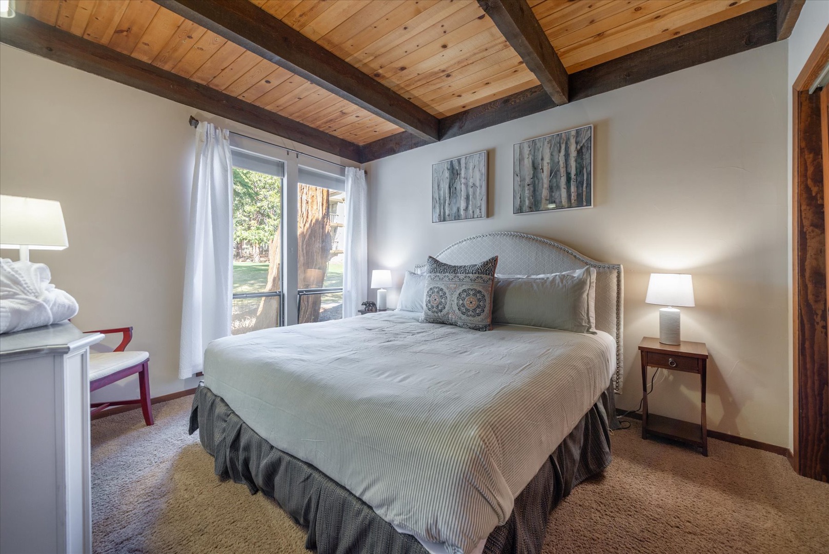 Unwind beneath rustic wooden beams in this serene bedroom, where soft linens and gentle lighting create your perfect retreat.