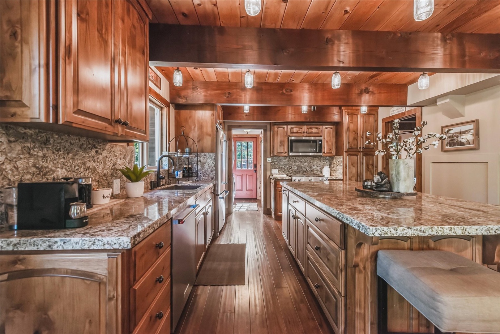 Your chef-worthy kitchen blends rustic charm with modern convenience, featuring warm wood cabinetry, gleaming granite countertops, and ample prep space for preparing memorable meals together.
