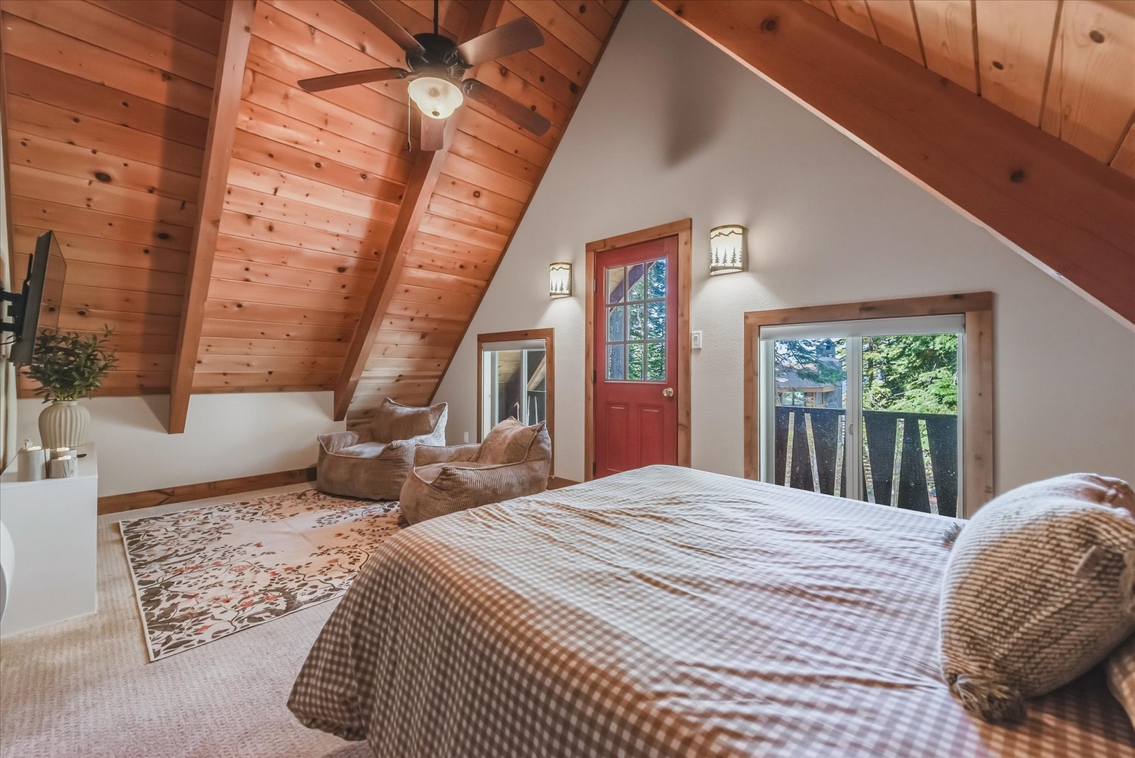 Drift off beneath soaring wood-beamed ceilings in your large upstairs primary bedroom where your private balcony opens to forest greenery and your cozy bed awaits beneath warm, natural light streaming in.