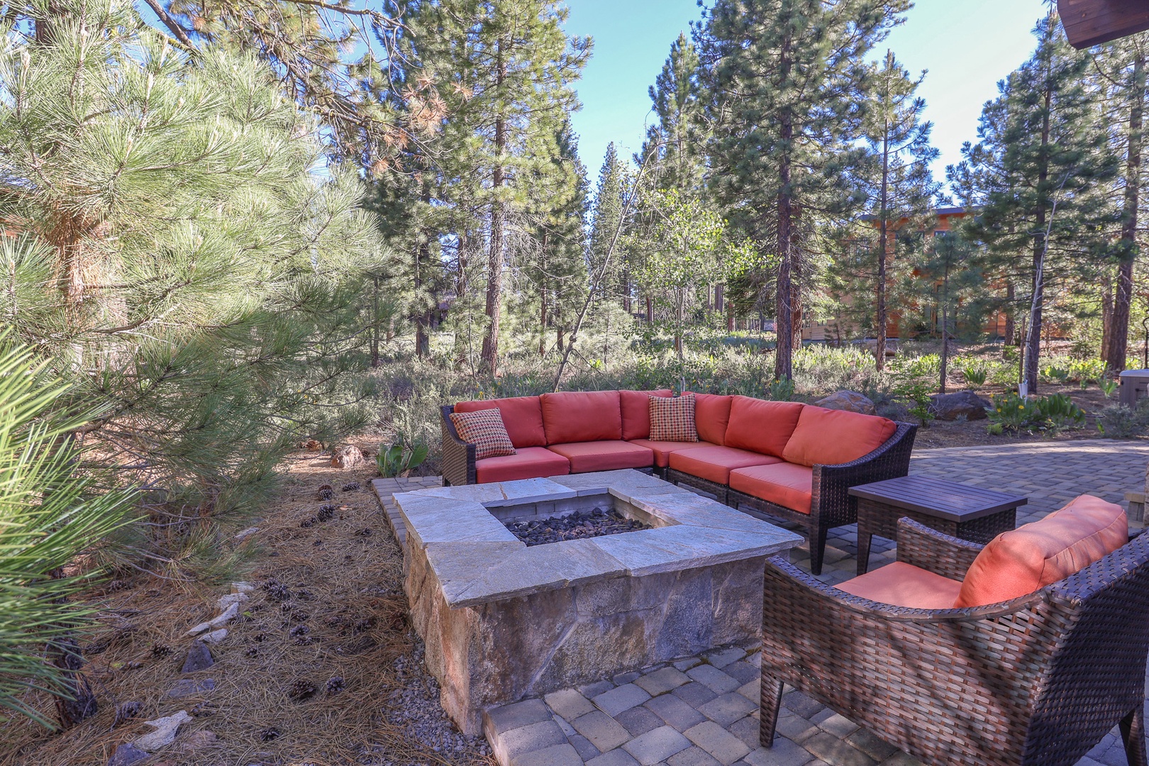 Gather around your private fire pit beneath towering pines, where plush seating and forest views create the perfect setting for relaxing evenings under open skies.