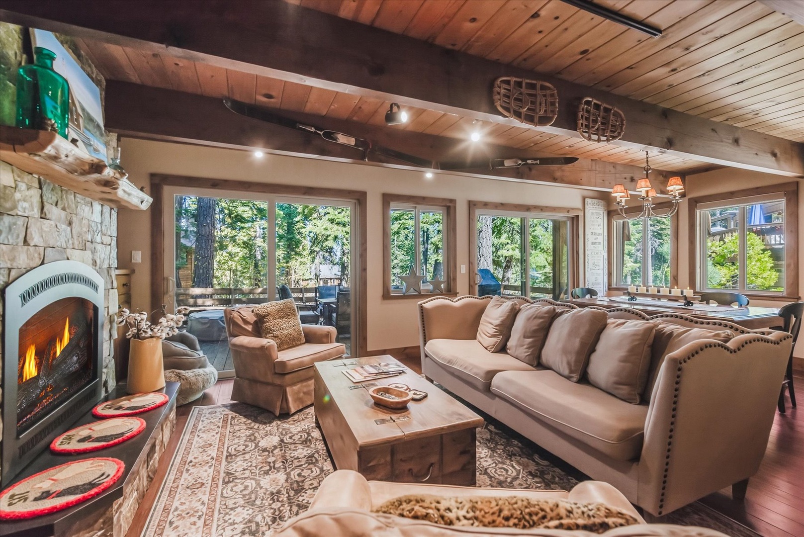Settle into plush seating while sunlight pours through towering windows framing the forest beyond—your alpine retreat awaits.