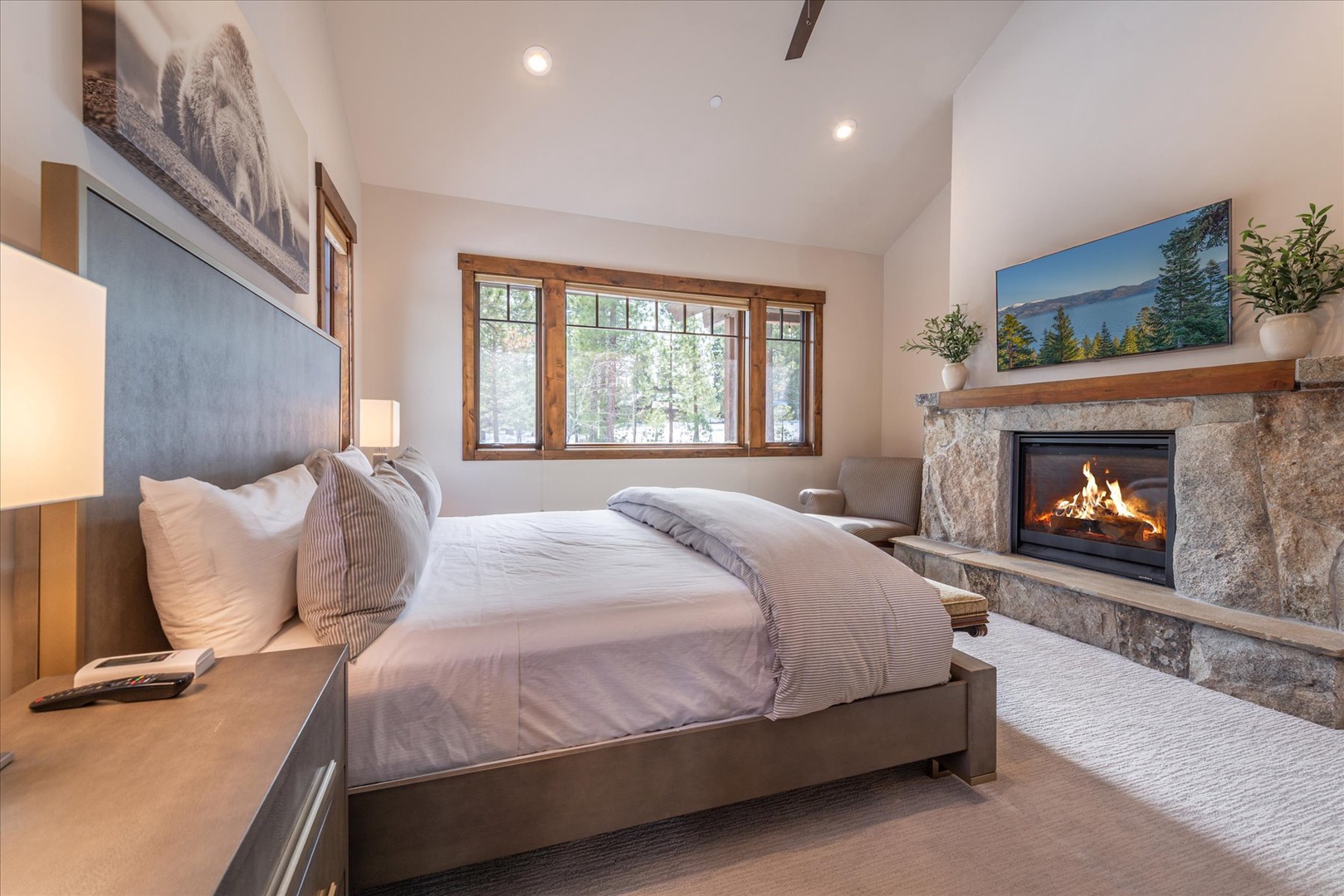 Sink into your king size bed in your cozy master bedroom sanctuary with crackling fireplace warmth and natural light streaming through forest views.