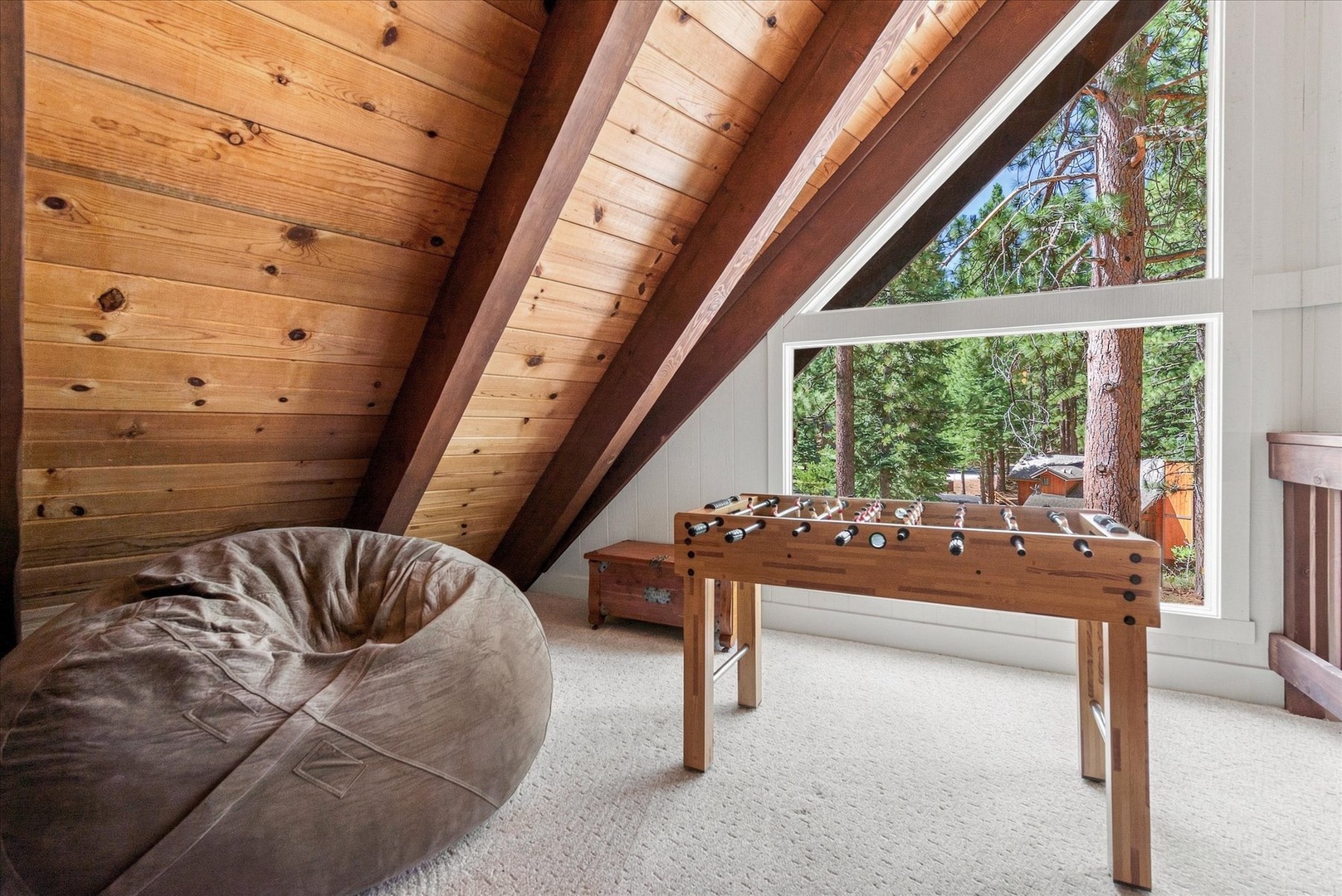 Challenge your travel companions to foosball in this cozy loft game room with vaulted wood ceilings and views of the surrounding forest.