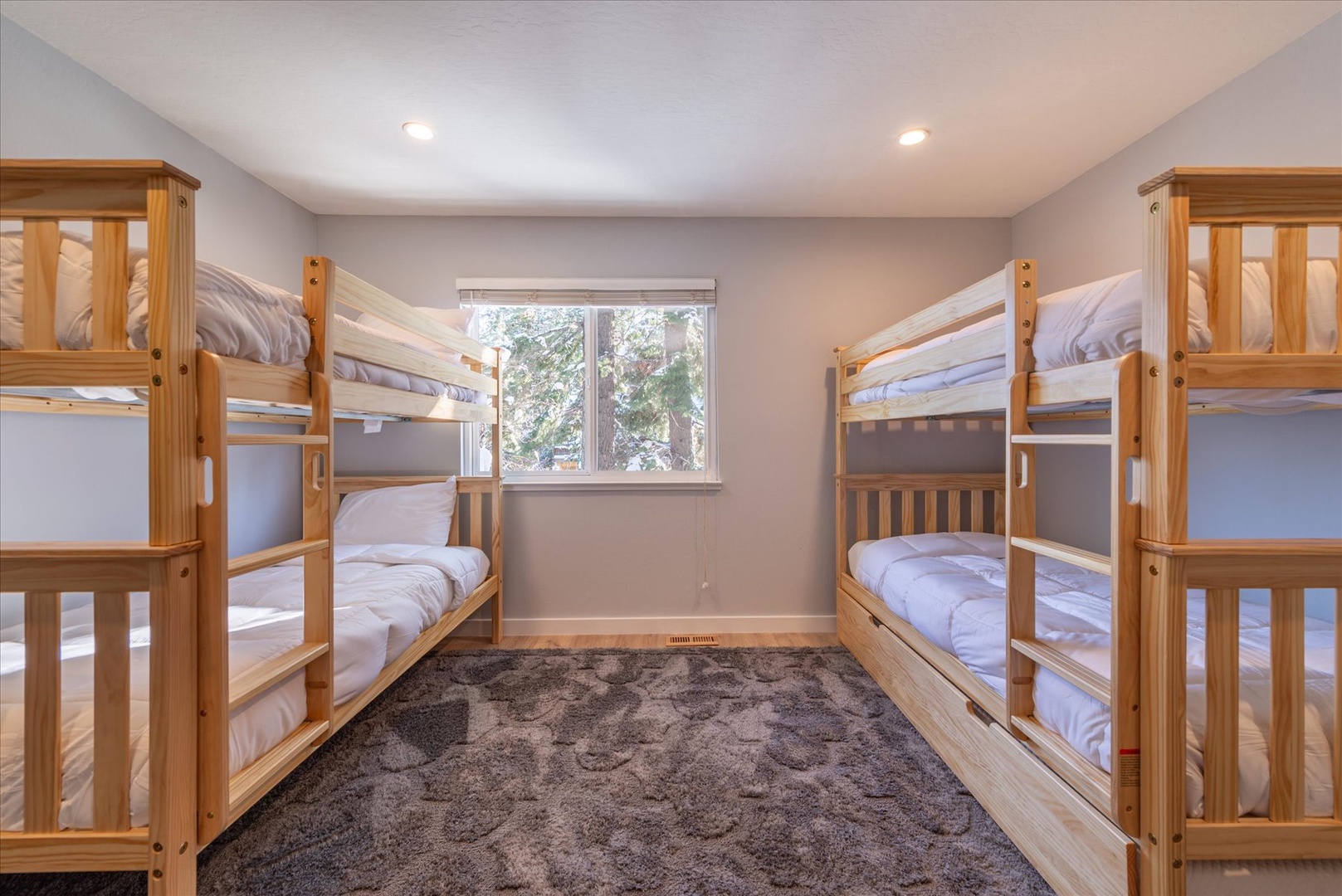 Your group will love this cozy bunk room with five comfortable beds and soft natural light streaming through the window. Four bunk beds and one trundle.