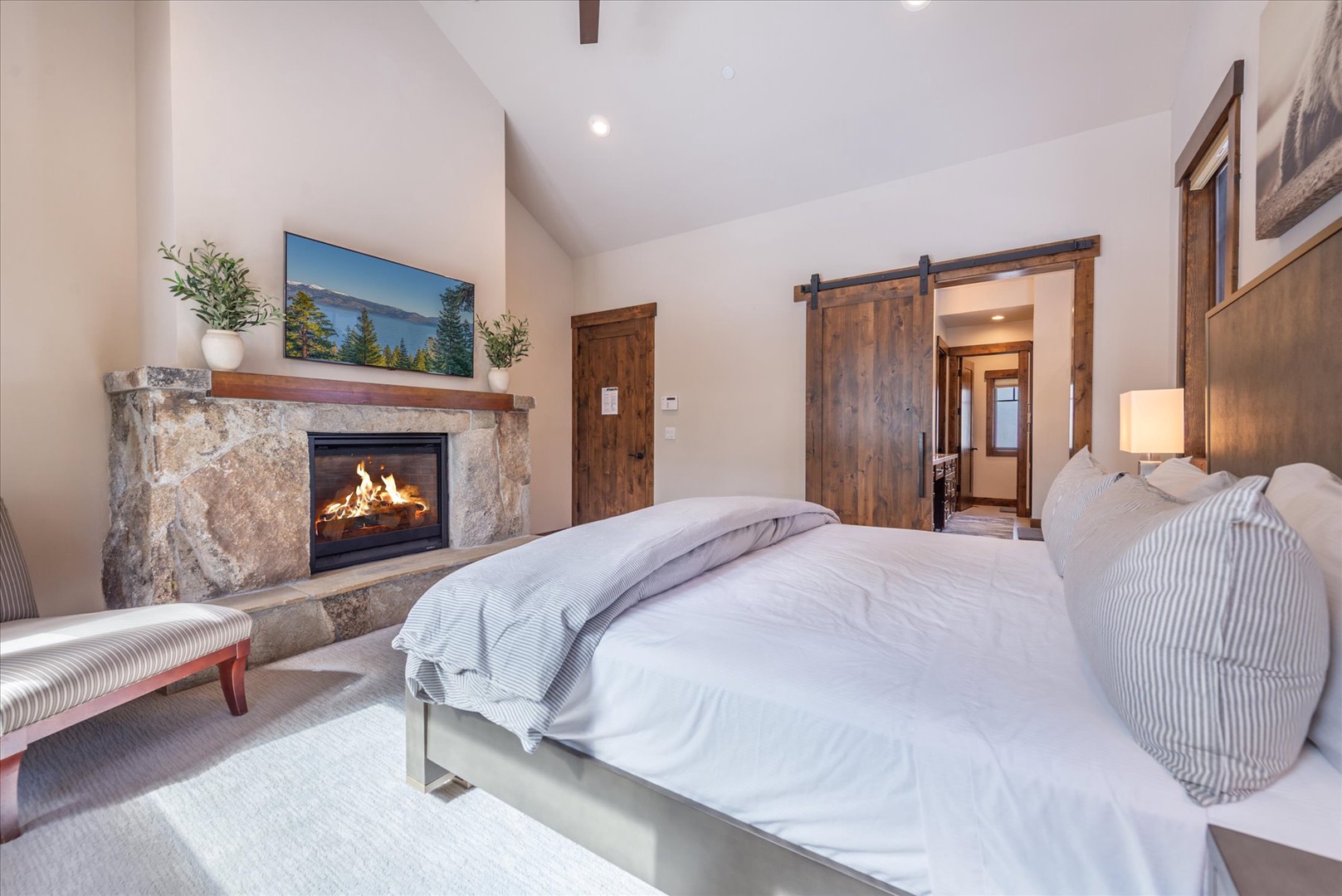 Drift off to sleep beside your crackling fireplace, wrapped in luxurious linens with rustic barn doors adding mountain lodge charm.