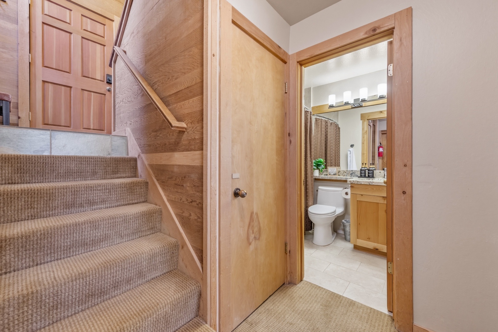 Step into your private bathroom where warm wood finishes and natural light create a welcoming retreat. Modern amenities meet cozy cabin charm for your comfort.
