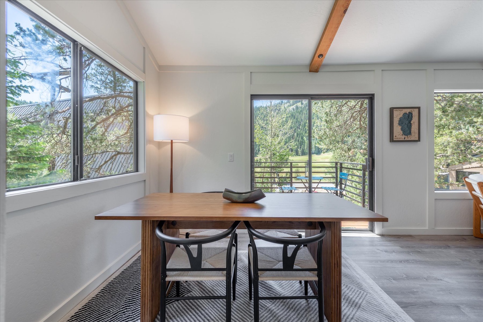Gather around this inviting dining table where natural light streams through large windows, framing peaceful garden views. Step out to your private balcony and breathe in the fresh air.