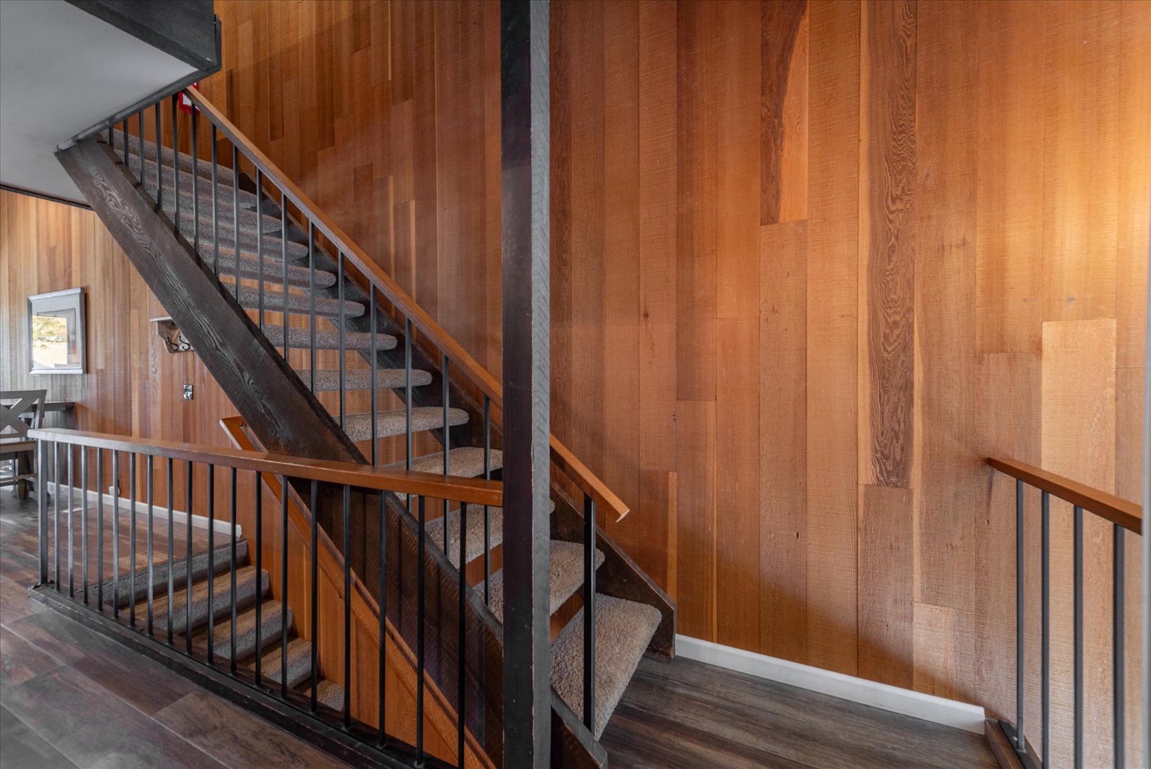 Wood paneled stairs connect this multi-level unit.