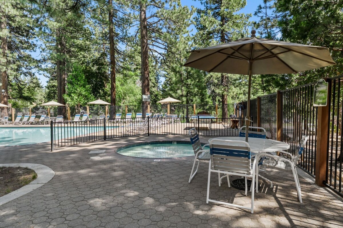 Relax under shaded umbrellas by the sparkling pool and hot tub, surrounded by towering pines in your private forest retreat.