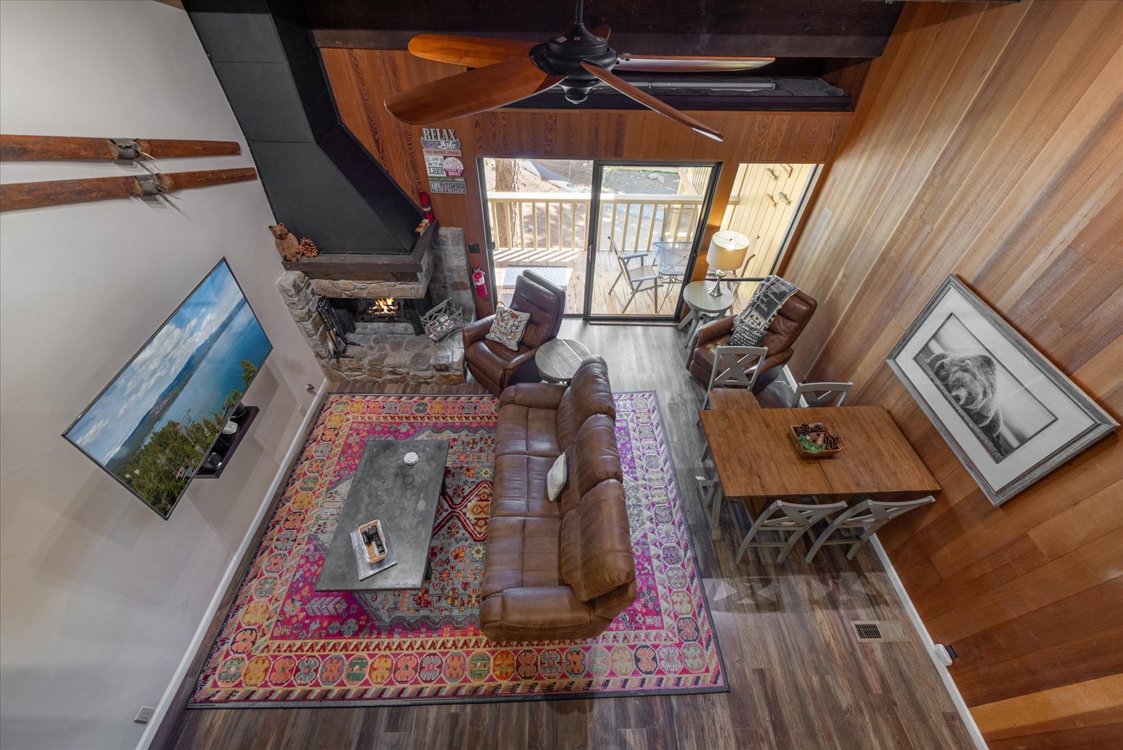 Cozy up in your open-concept living space with stone fireplace, leather seating, and balcony access for mountain retreats.