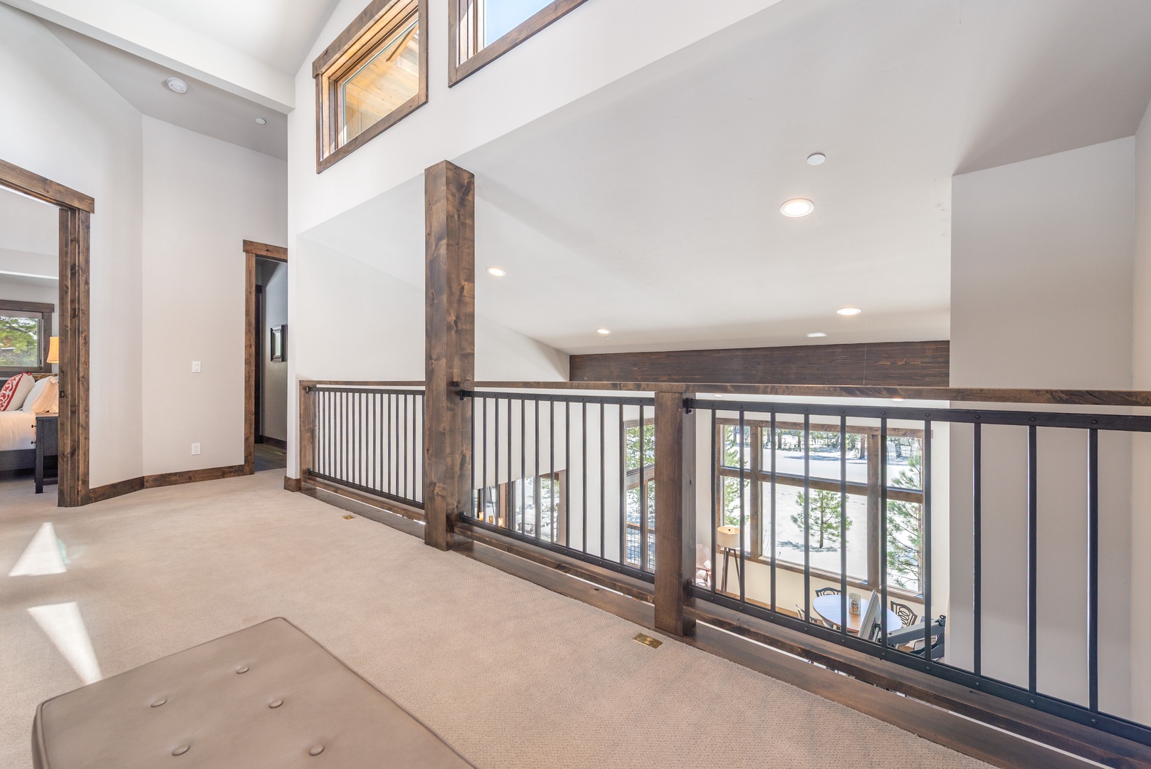 Your private loft overlooks the living area below, creating an airy retreat with soaring ceilings and warm wood accents throughout.