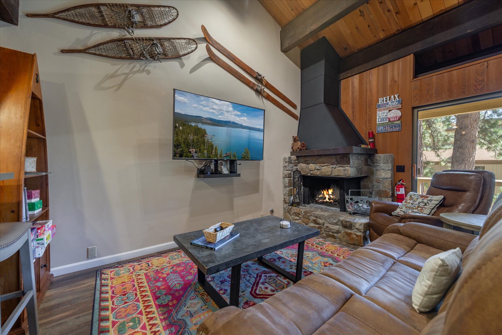 Sink into plush leather seating by your crackling stone fireplace, where vintage skis add mountain charm to cozy evenings.