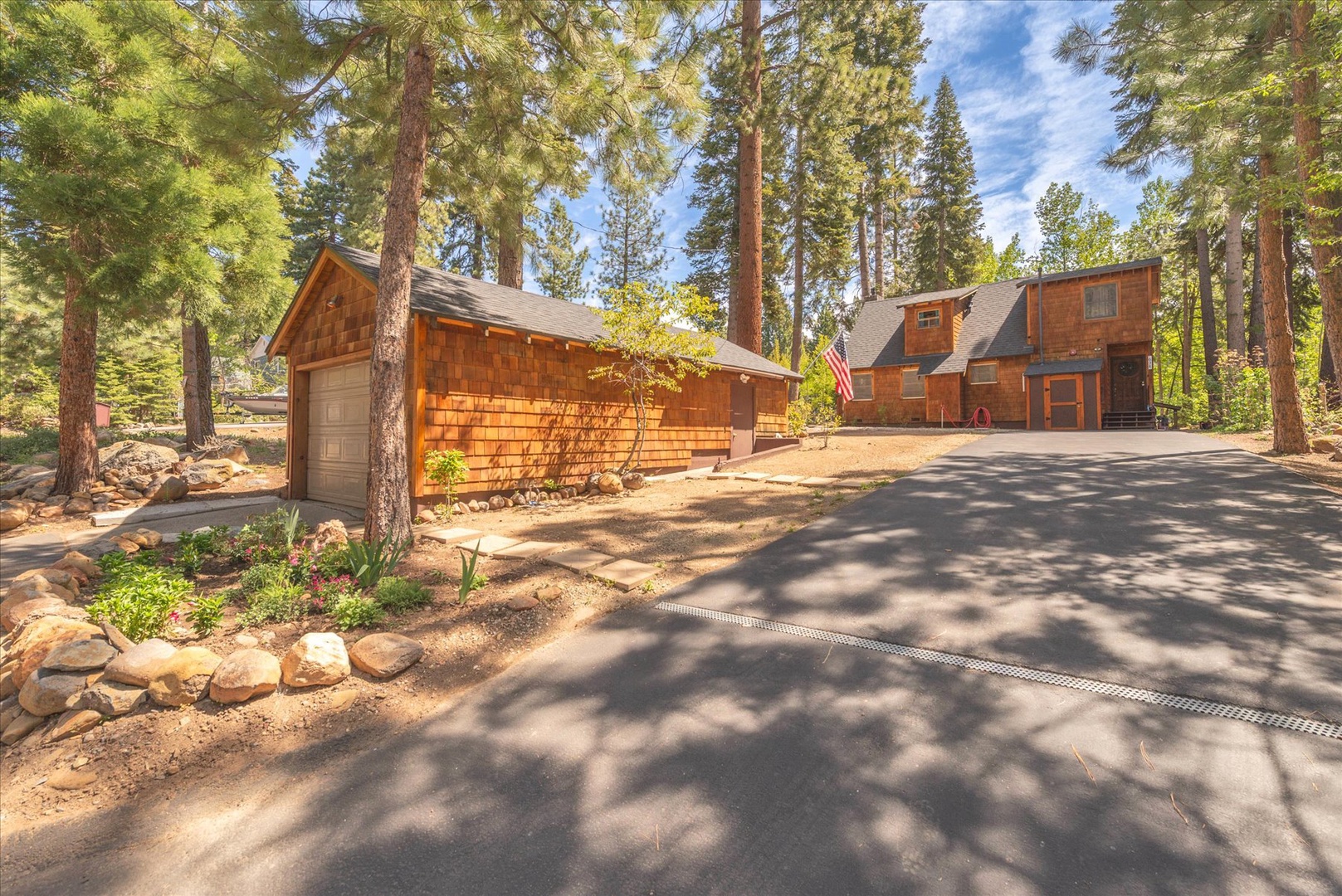 Charming wood-shingled cabin nestled among towering pines with private driveway and wooded setting for peaceful mountain retreat.