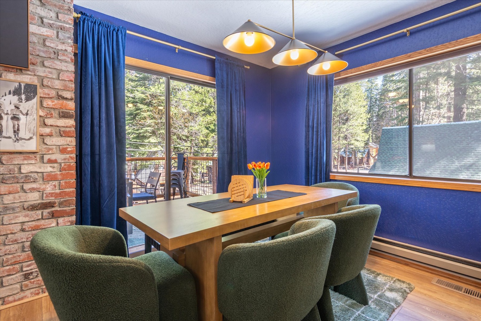 Gather around your elegant dining table where bold blue walls and warm pendant lighting create the perfect atmosphere for memorable meals.