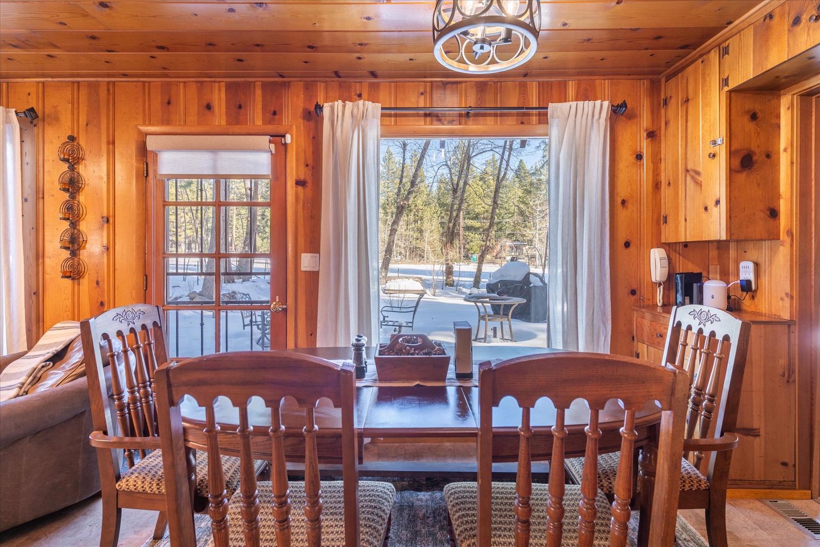 Gather around this warm wooden dining table where meals become memories, with forest views framing your retreat perfectly.