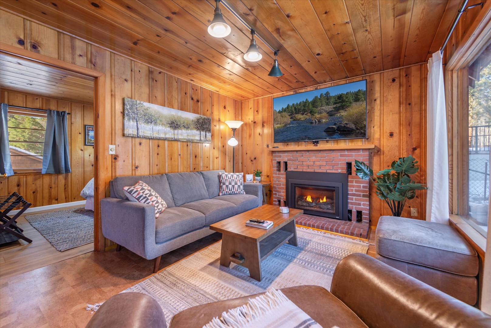 Cozy up in your mountain cabin living room where ample lighting, comfy seating, and a crackling fireplace creates perfect evenings.