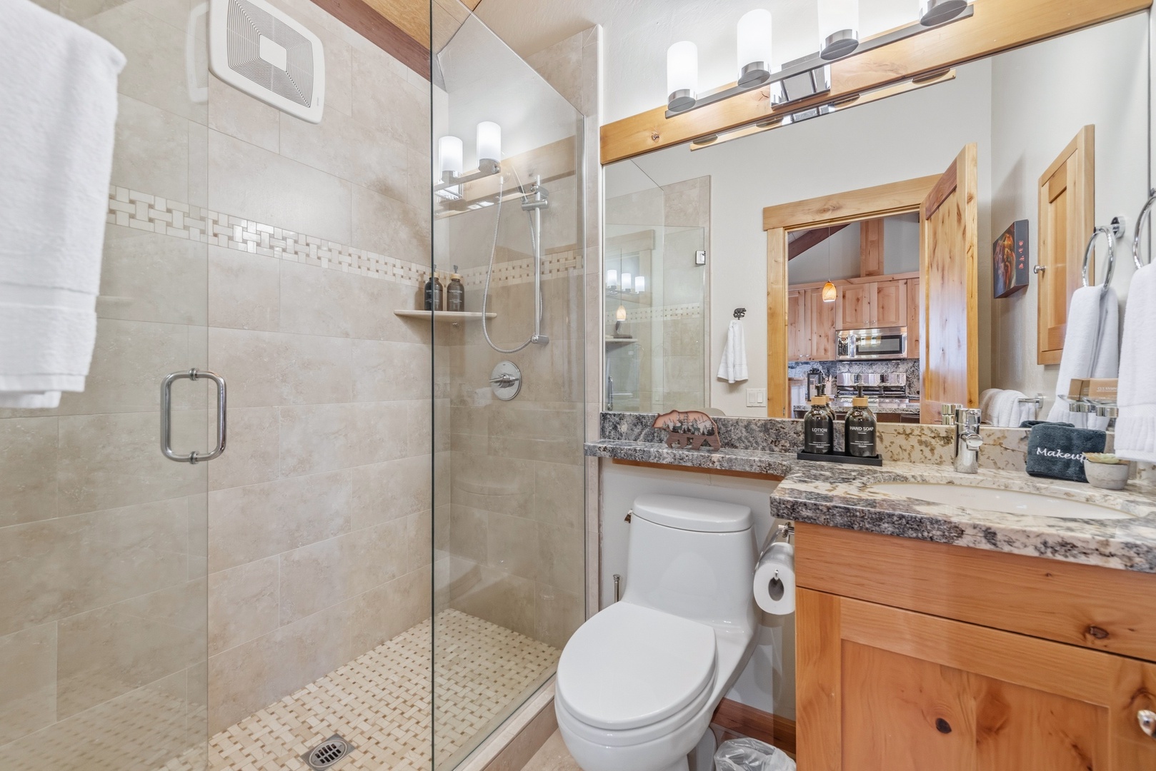 Step into your beautifully appointed bathroom featuring a spacious walk-in shower, elegant granite countertops, and warm wood accents that create a serene, spa-like retreat for your mountain getaway.