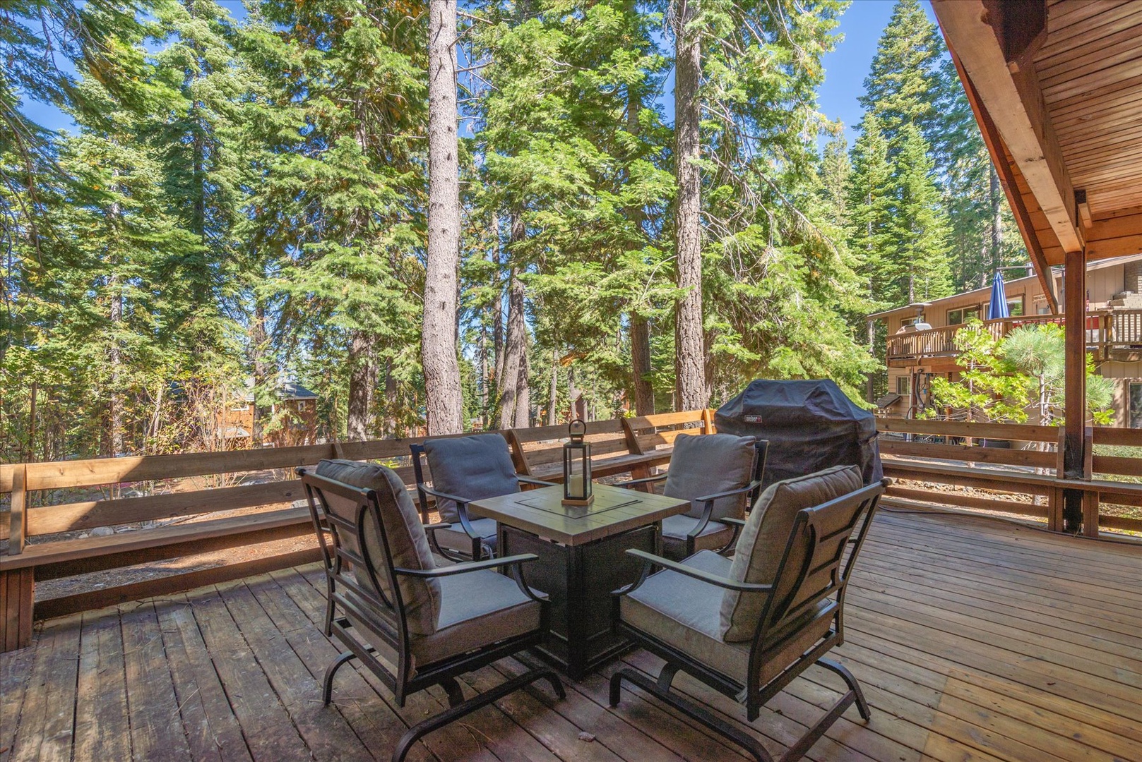 Surrounded by towering pines and dappled sunlight, this spacious deck invites you to gather around the fire table, fire up the grill, and breathe in the fresh mountain air.