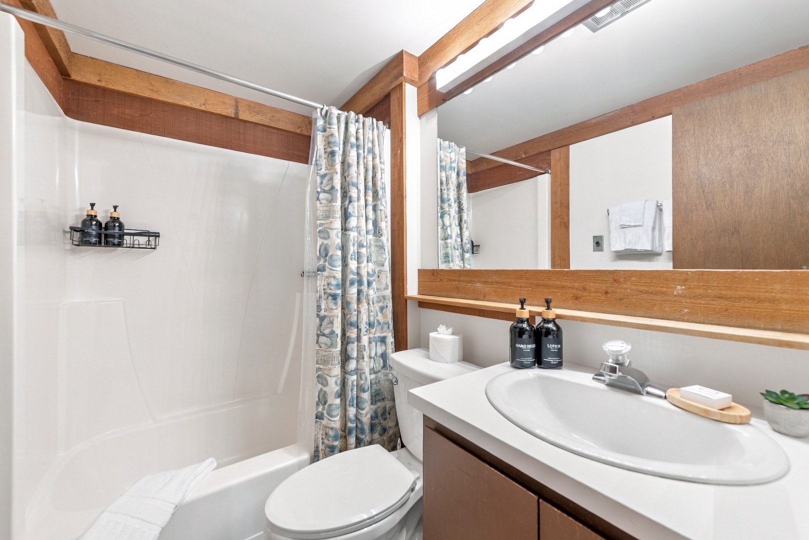 Step into your private bathroom with warm wood accents and quality fixtures. Fresh towels, full-size amenities, and a soothing tub-shower combo make this your perfect refresh space.