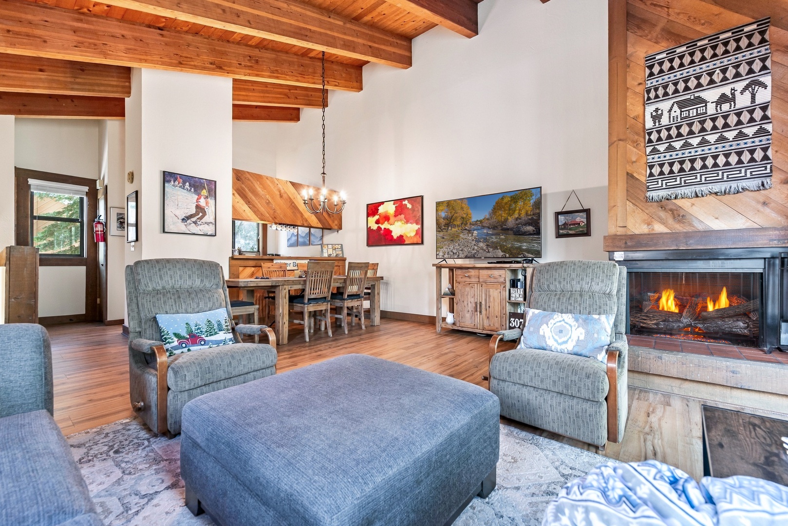Unwind in your spacious living room with vaulted wood-beam ceilings, a crackling fireplace, and comfortable seating that invites you to relax after a day of mountain adventures.