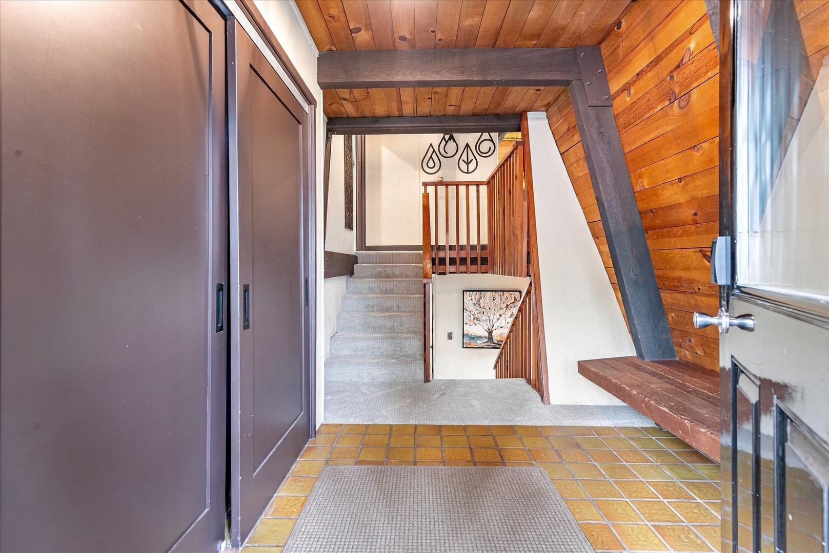 Step into your mountain retreat through a welcoming entry where warm wood beams and natural light create an inviting first impression of your home away from home.