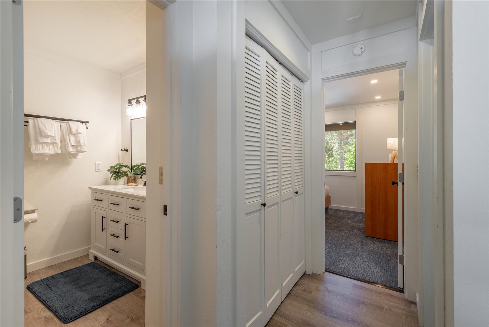 A peaceful hallway connects your bathroom and bedroom, with fresh towels ready and natural light streaming in to brighten your stay.