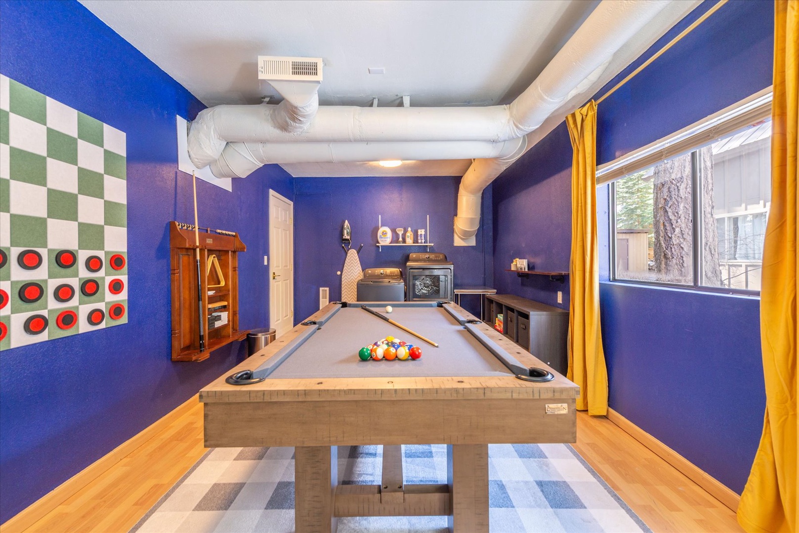 Your private game room awaits with a pool table, life sized games, and vibrant blue walls creating the perfect space for friendly competition.