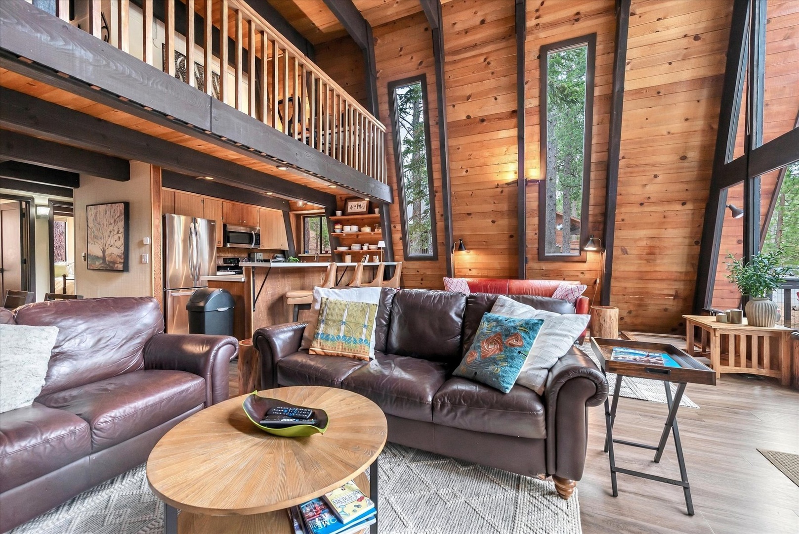 Sink into soft leather seating beneath soaring cathedral ceilings where warm wood surrounds you and floor-to-ceiling windows frame lush forest views.
