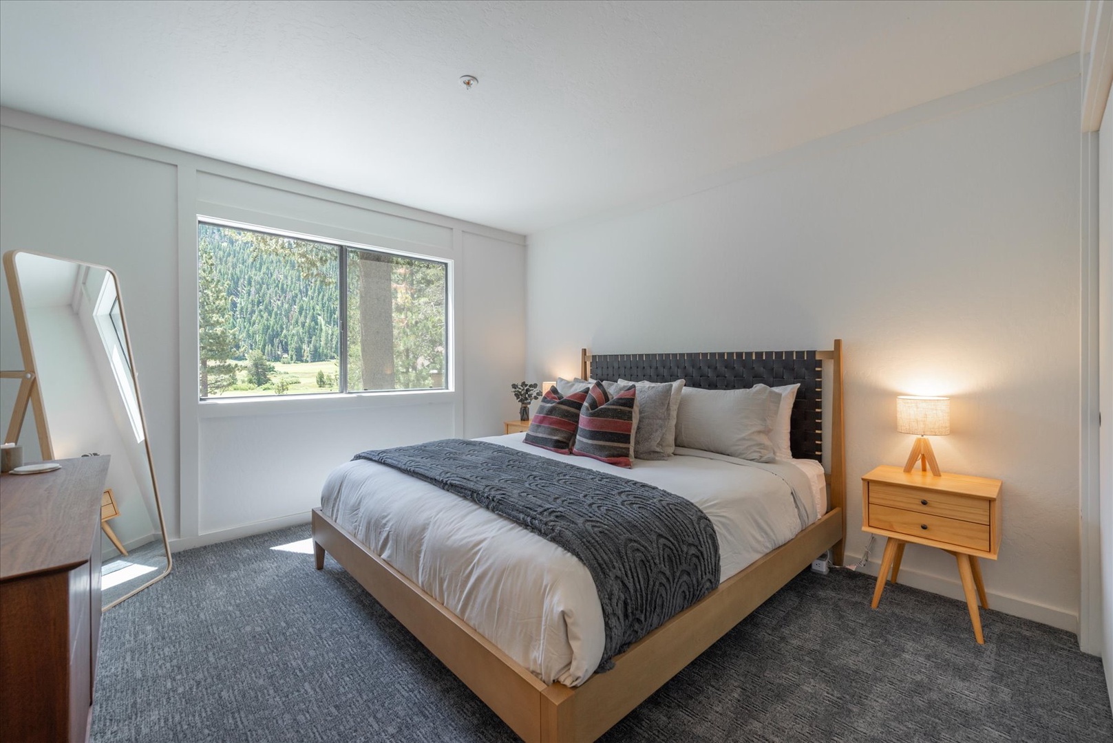 Wake up to serene forest views from your comfortable bed in this peaceful, modern bedroom designed for restful mountain mornings.